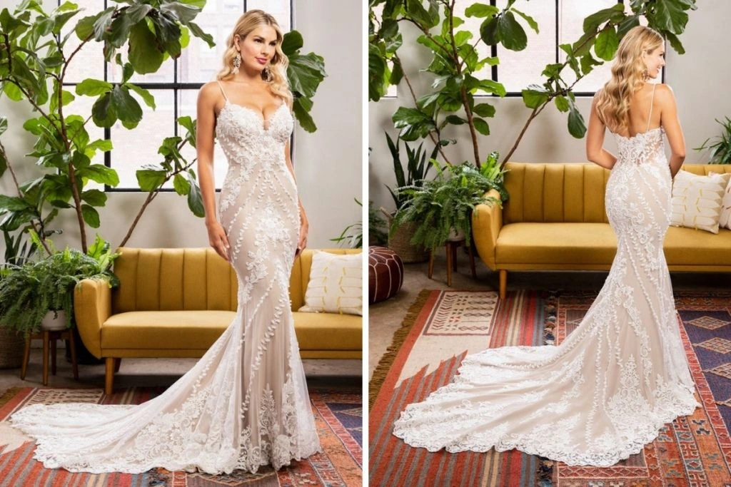 Sneak Peek: Casablanca Bridal Tester Event Front and back views of a fitted lace wedding gown with spaghetti straps, floral appliqués, and a long scalloped train, photographed in a modern studio with plants and a mustard sofa.