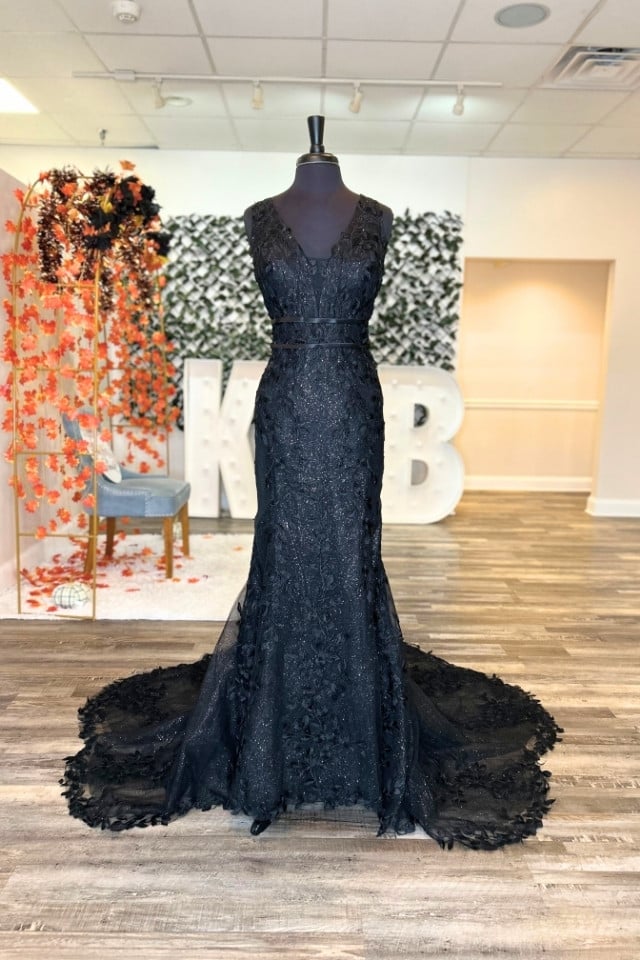 Page Updates & Announcements Black lace fit-and-flare wedding gown with plunging V-neck, floral appliqués, double waistband, and dramatic train.