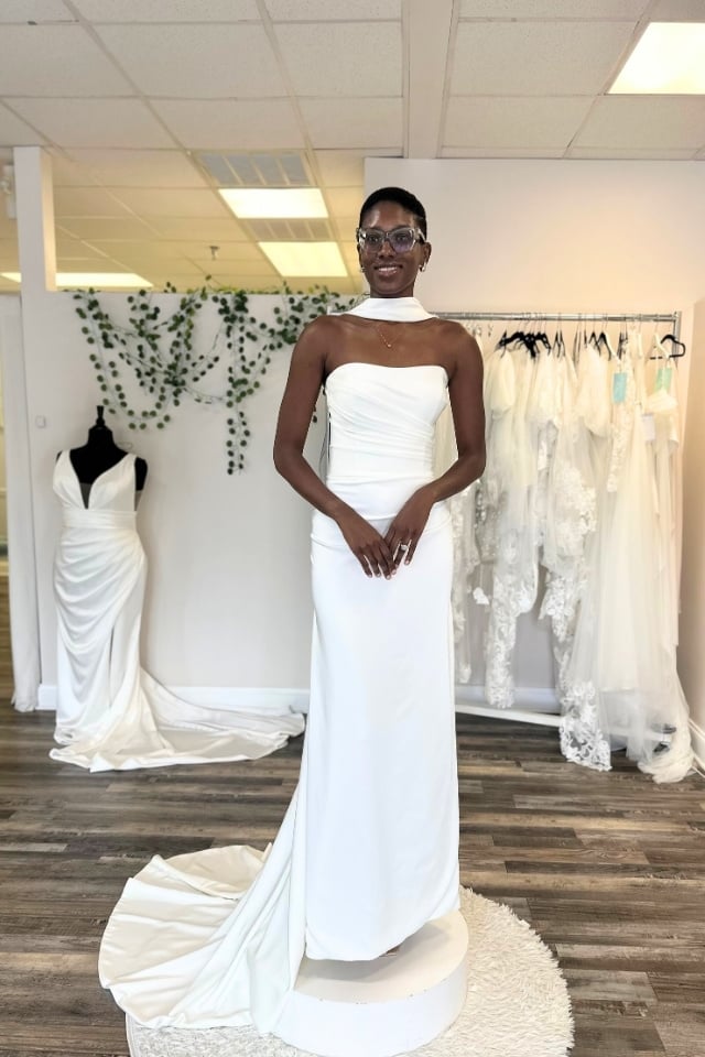 K&B Bridals | Premier Bridal Shop in Maryland Bride modeling a modern strapless satin wedding gown with asymmetrical ruching and a detachable choker neckline.