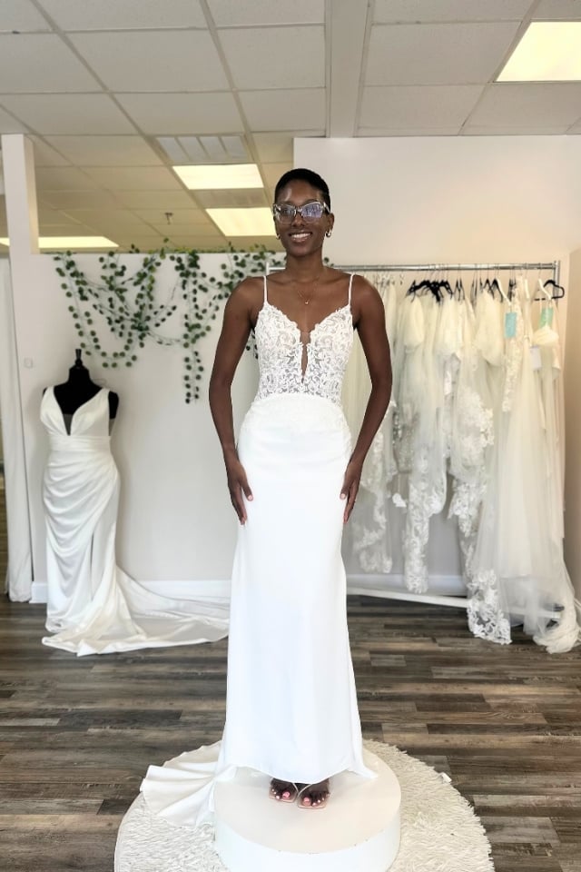 Page Updates & Announcements Bride wearing a fitted wedding dress with a sheer lace bodice, thin straps, and crepe skirt with a minimal train.