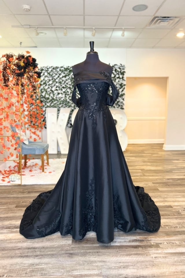 Page Updates & Announcements Off-the-shoulder black ball gown wedding dress with lace sequin appliqués, full satin skirt, and dramatic chapel train.
