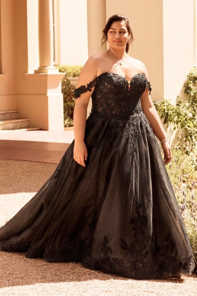 Black off-the-shoulder ball gown wedding dress with glitter tulle, lace appliqués, and chapel-length train.