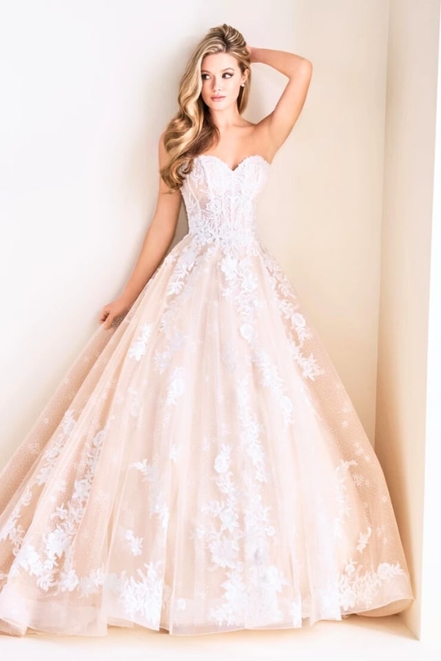 Strapless glitter tulle ball gown with sweetheart neckline, floral lace appliqués, and corset back.