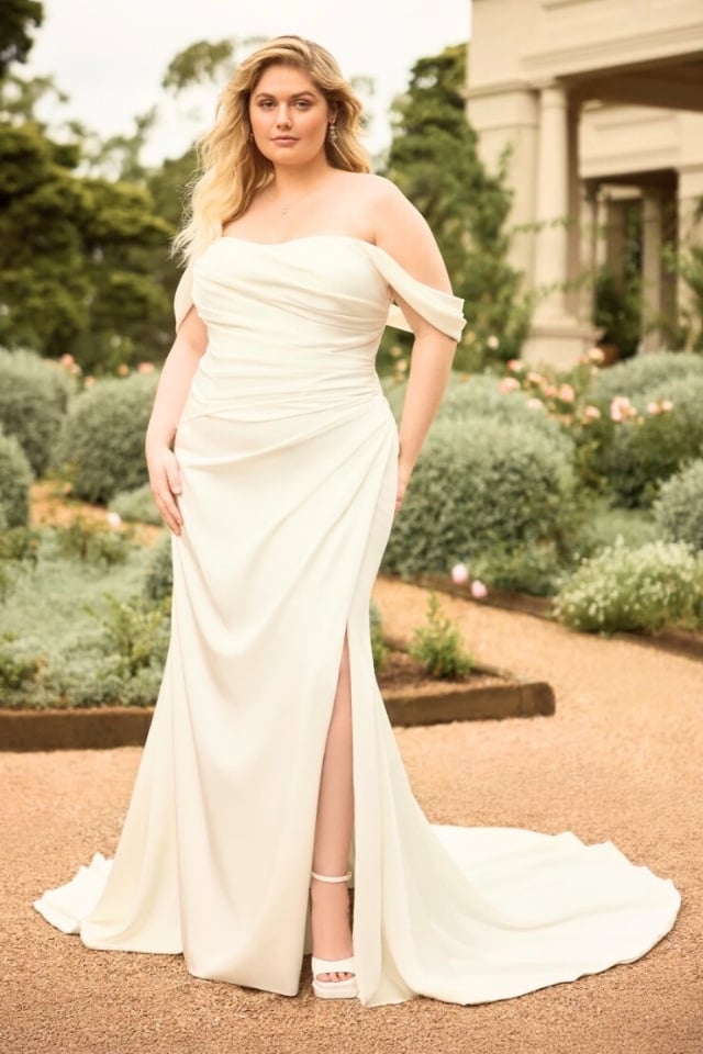 Off-shoulder satin crepe mermaid wedding dress with draped bodice and chapel-length train.