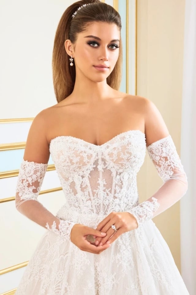 Romantic Lace A-Line Wedding Gown MT9112 Begonia Bride wearing a romantic lace A-line wedding gown with sweetheart neckline and long lace train, styled with detachable long sleeves.
