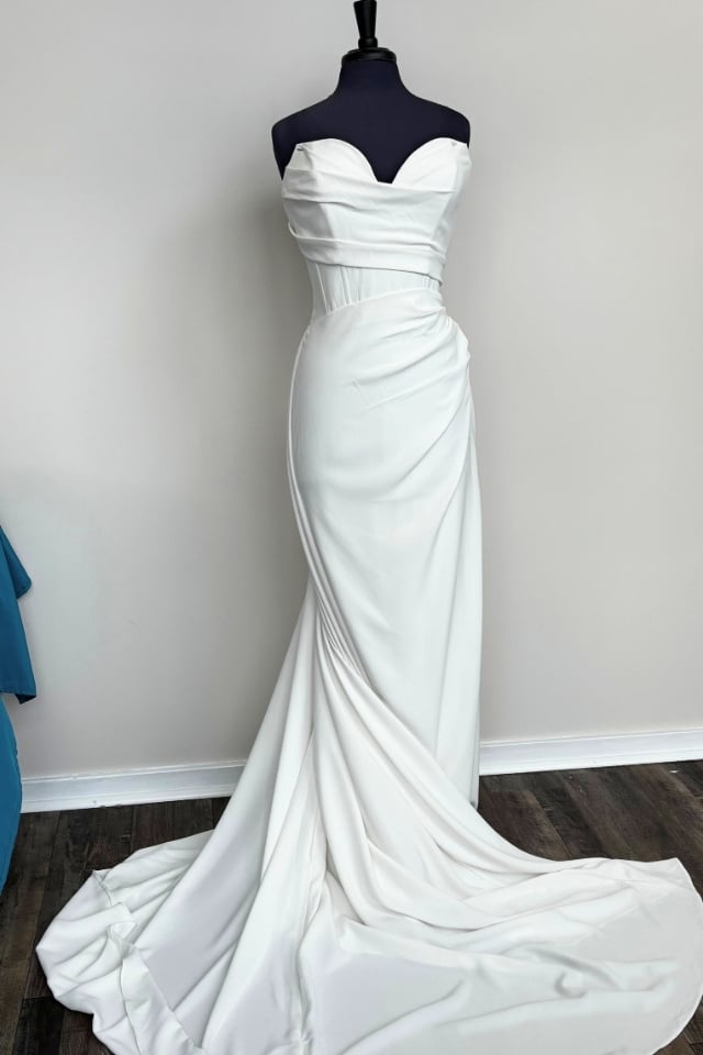 Ivory crepe fit and flare wedding gown on mannequin with ruched sweetheart corset bodice and soft draped skirt