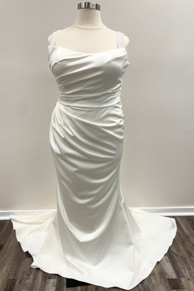 Ivory satin fit and flare wedding dress with ruched bodice and beaded straps on mannequin