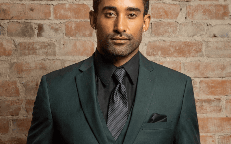 close up photo of a man wearing an emerald green tux