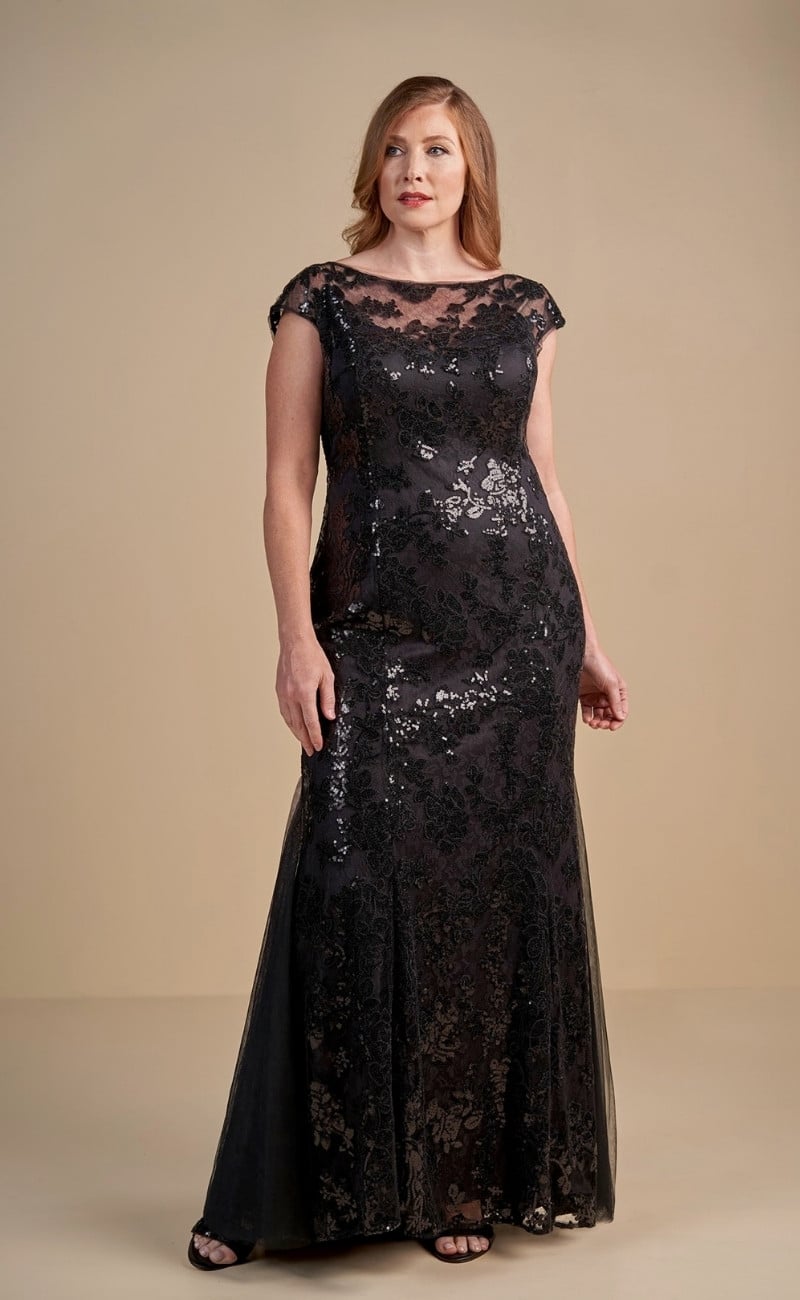Jade Couture K198011 mother of the bride gown featuring a long boat neckline, sequin lace overlay with netting, short sleeves, a flattering flare skirt, and a sweep train in navy