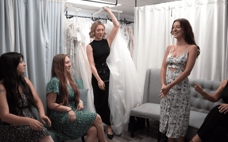 brides and stylist showing a wedding dress