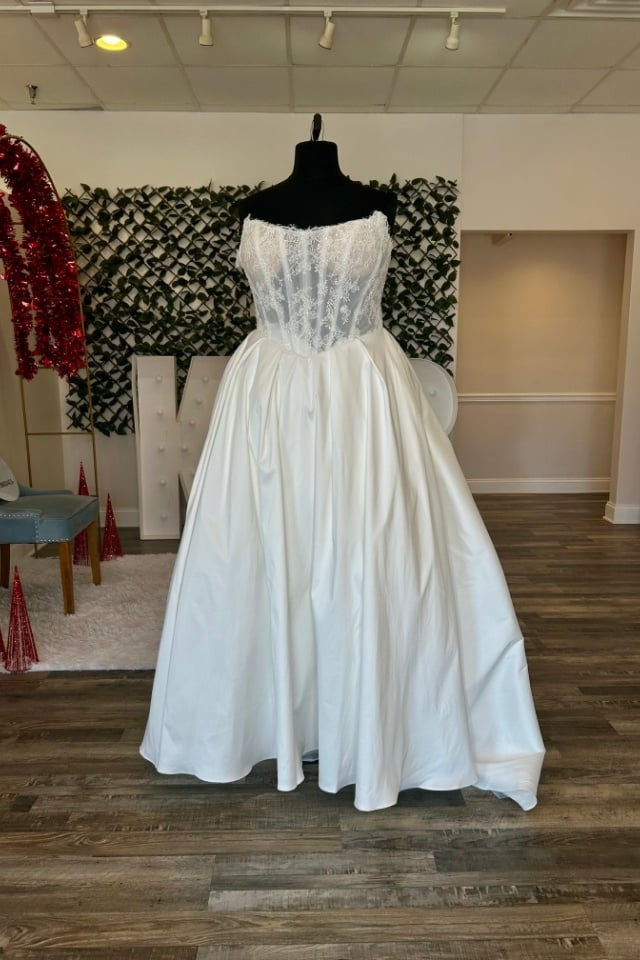 Page Updates & Announcements Strapless lace bodice ball gown wedding dress with full satin skirt displayed on mannequin in bridal boutique.