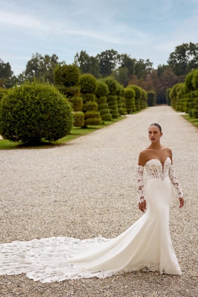 Fit-and-flare lace and crepe wedding gown with sweetheart plunge neckline and cathedral train.