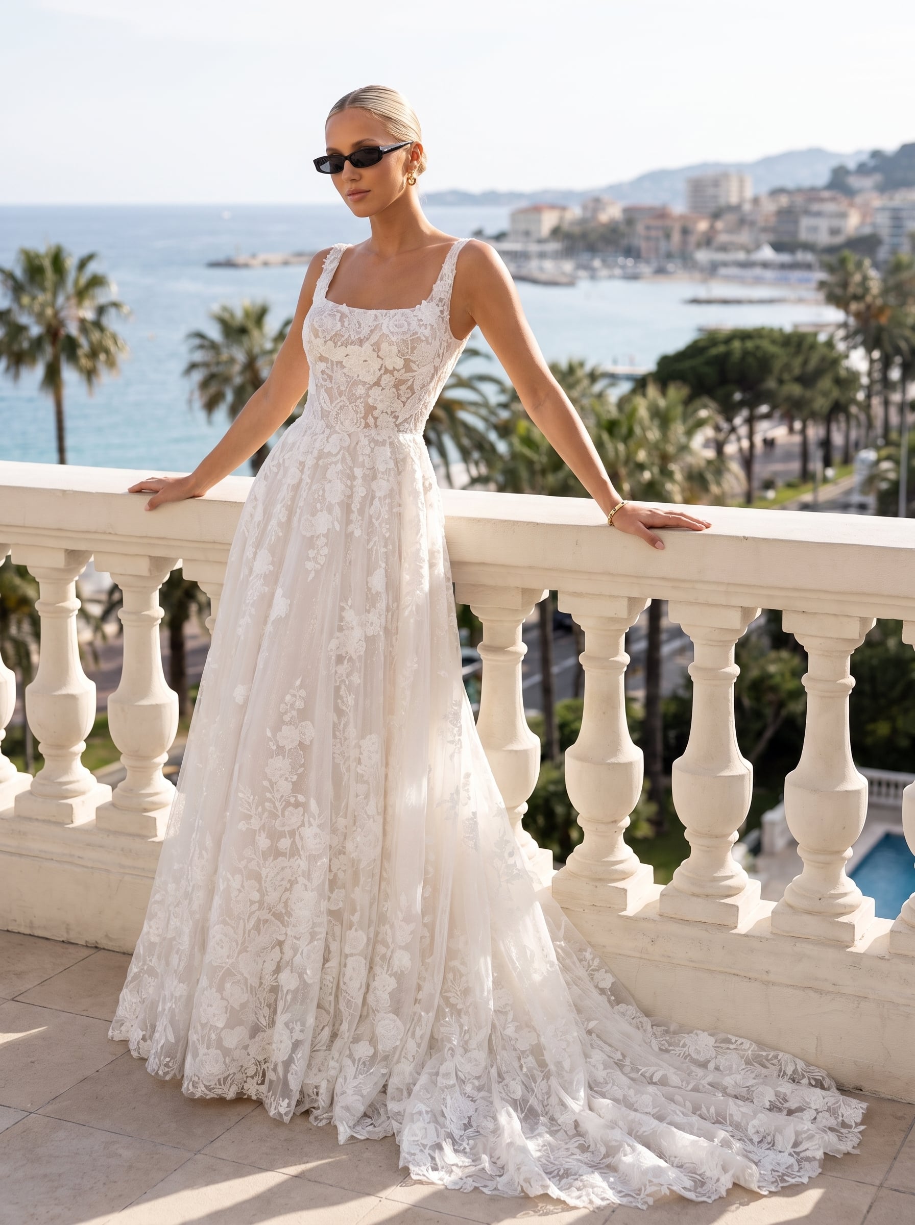 Square-neck lace ball gown wedding dress with wide straps, floral lace appliqués, a full flowing skirt, and a long lace train.