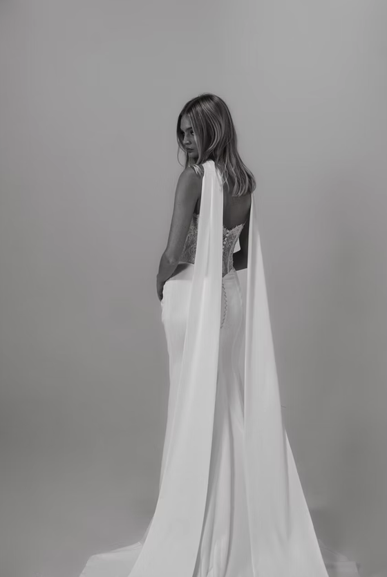 Modern Lace and Satin Fit-and-Flare Wedding Dress Zara Zara fitted lace and satin wedding dress featuring a straight-across strapless neckline, sheer corset bodice with exposed boning, floral lace detailing, draped satin skirt, removable lace sleeves, and coordinating satin neck scarf.
